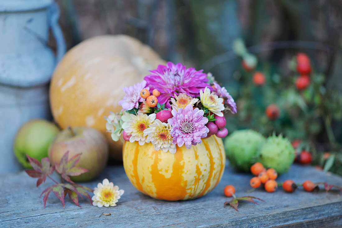 Small bouquet of chrysanthemums in a pumpkin as a vase