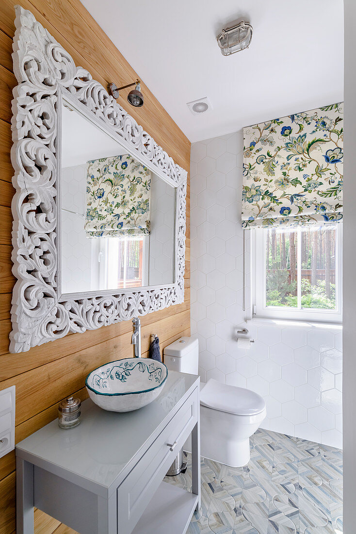 Mirror with elaborate frame above sink
