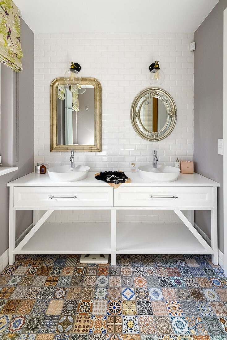 Two different mirrors above twin sinks on washstand