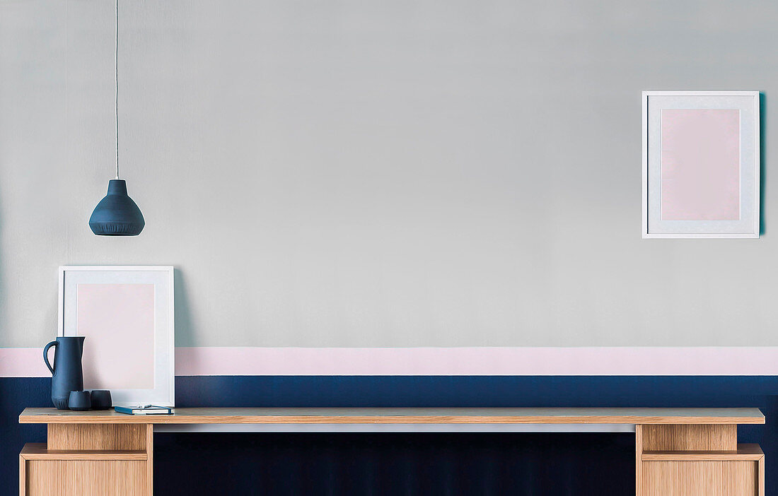 Long desk in front of gray-blue wall with pink stripes