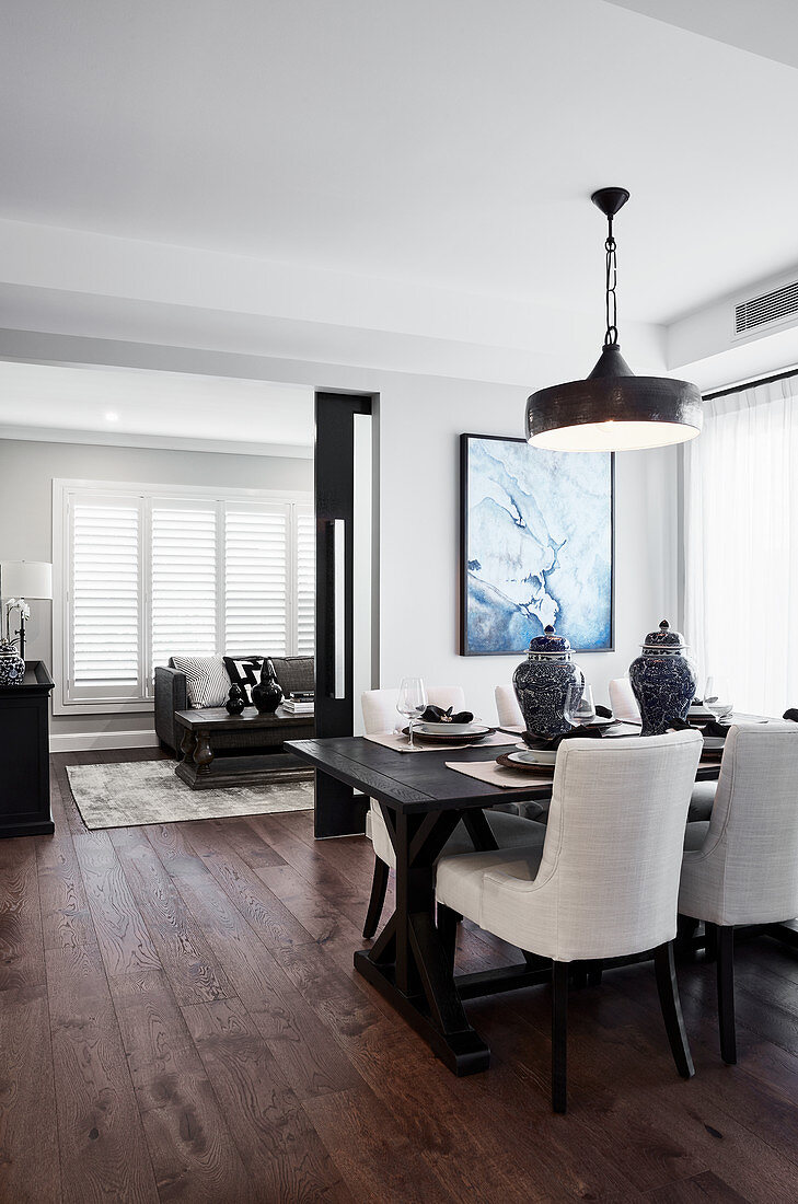 Dark table and upholstered chairs in dining room with dark wooden floor