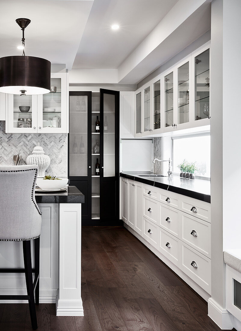 White counter with black worksurface in open-plan kitchen