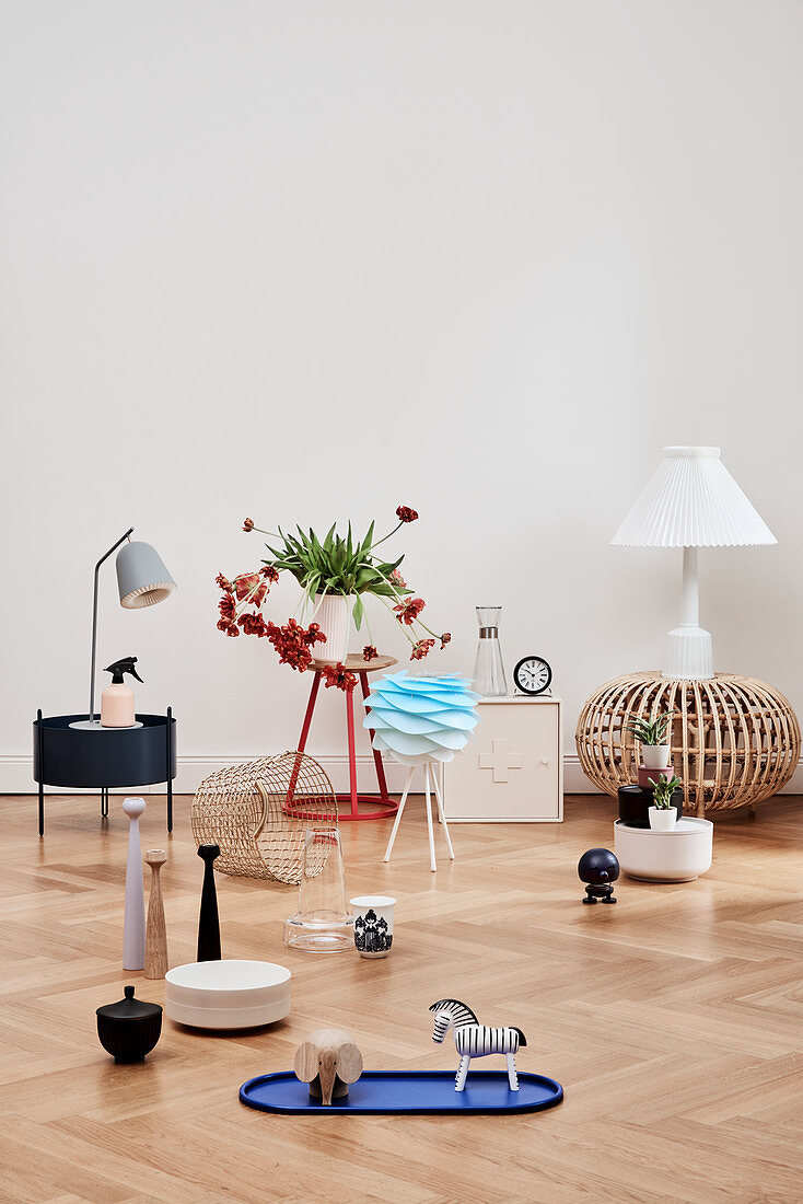 Various ornaments on side table and on pale parquet flooring