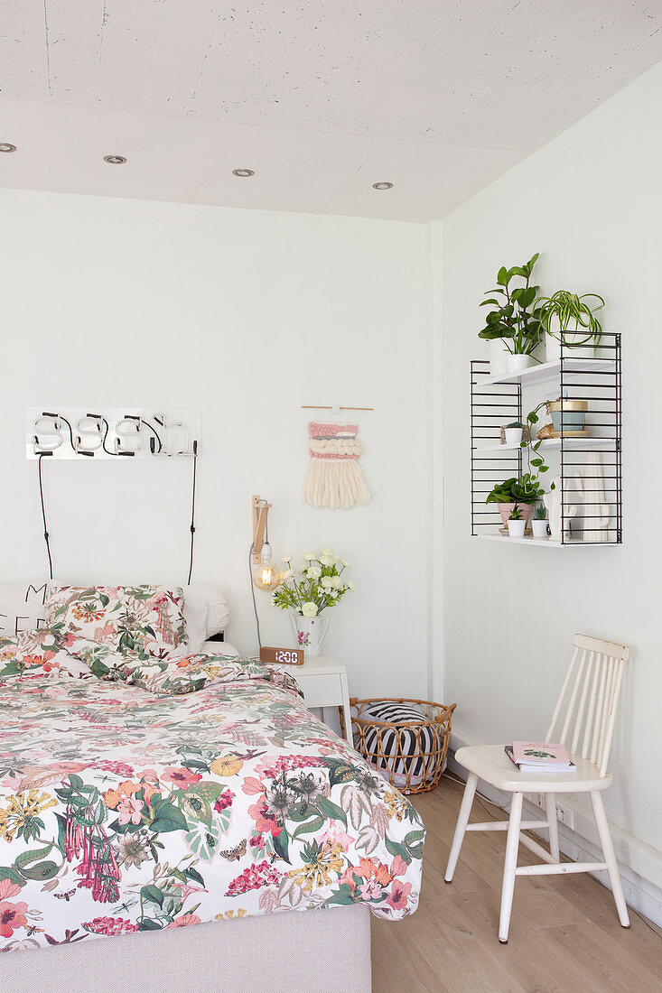 Floral gemusterte Bettwäsche auf dem Bett im Schlafzimmer in Weiß