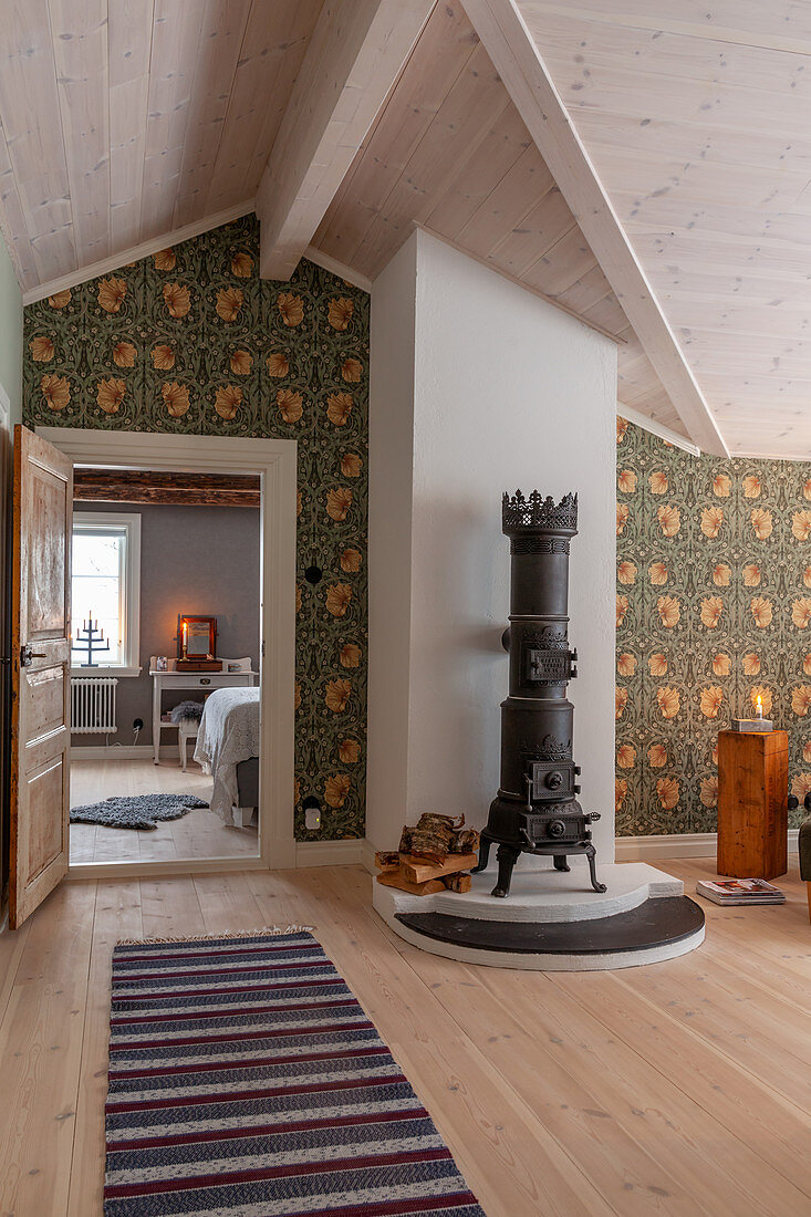 Luftiges Wohnzimmer mit antikem Gusseisenofen und Tapete