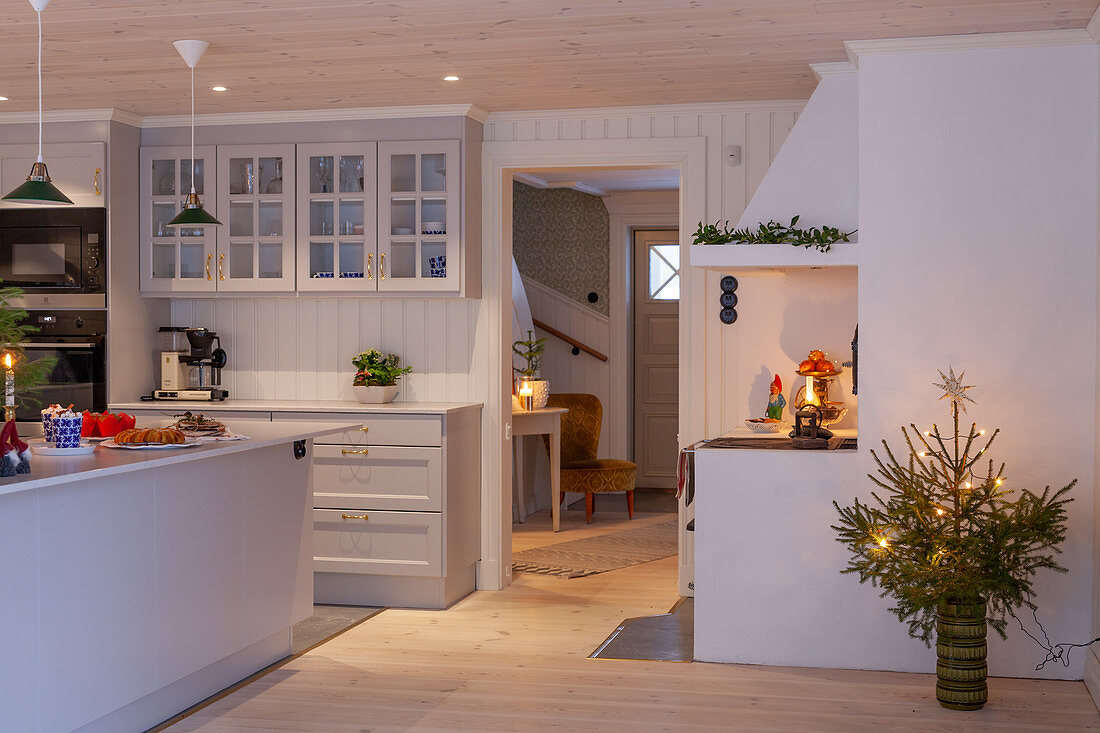 Island counter in festively decorated, white kitchen