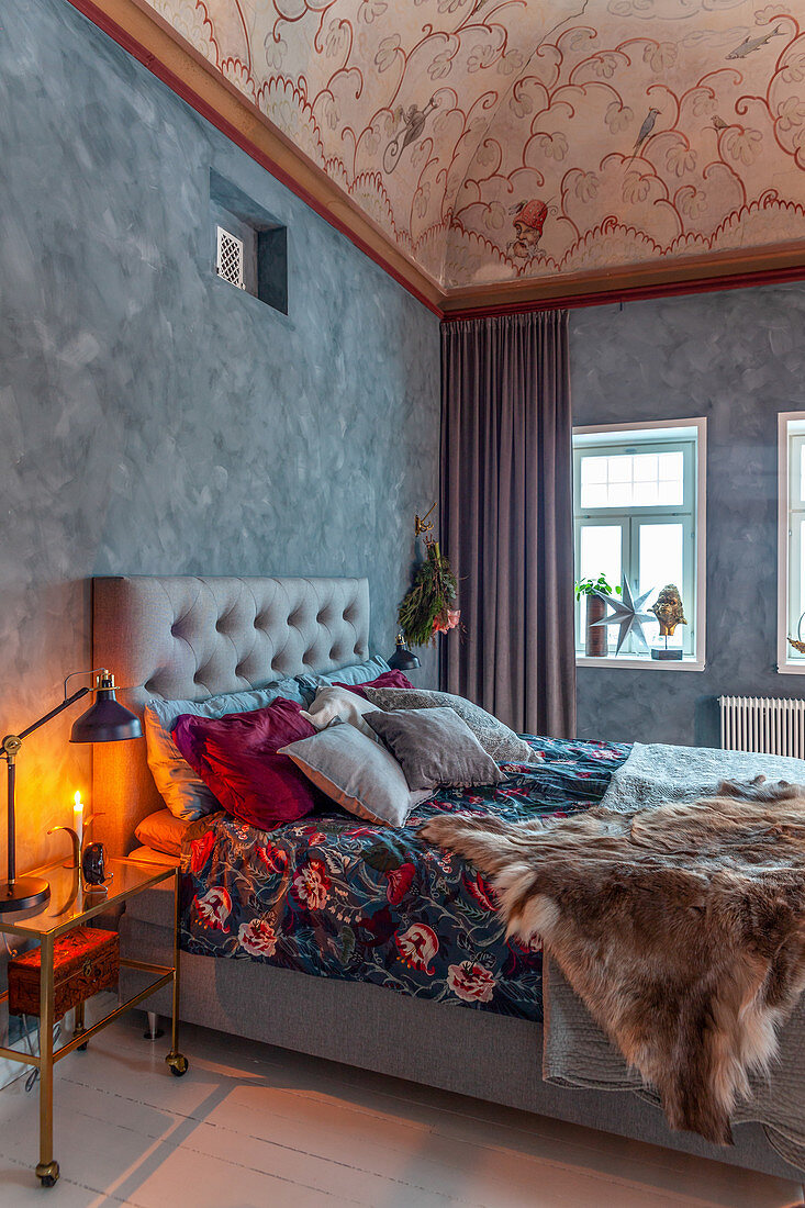 Elegant rustic bedroom with mottled painted wall and ornately painted ceiling