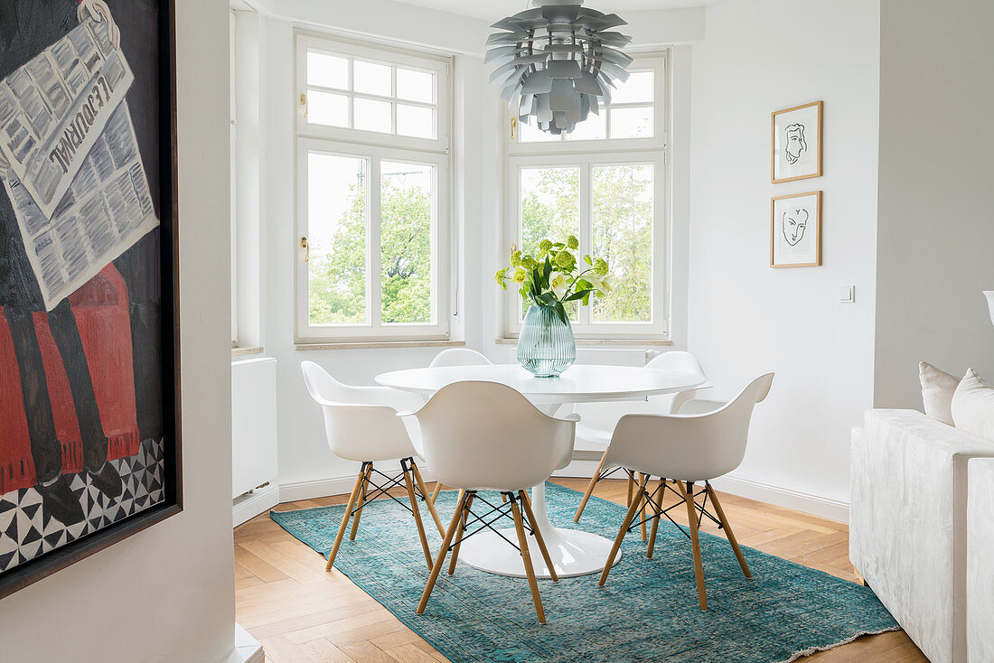 Tulip Table mit klassischen Schalenstühlen in weißem Erker einer Altbauwohnung