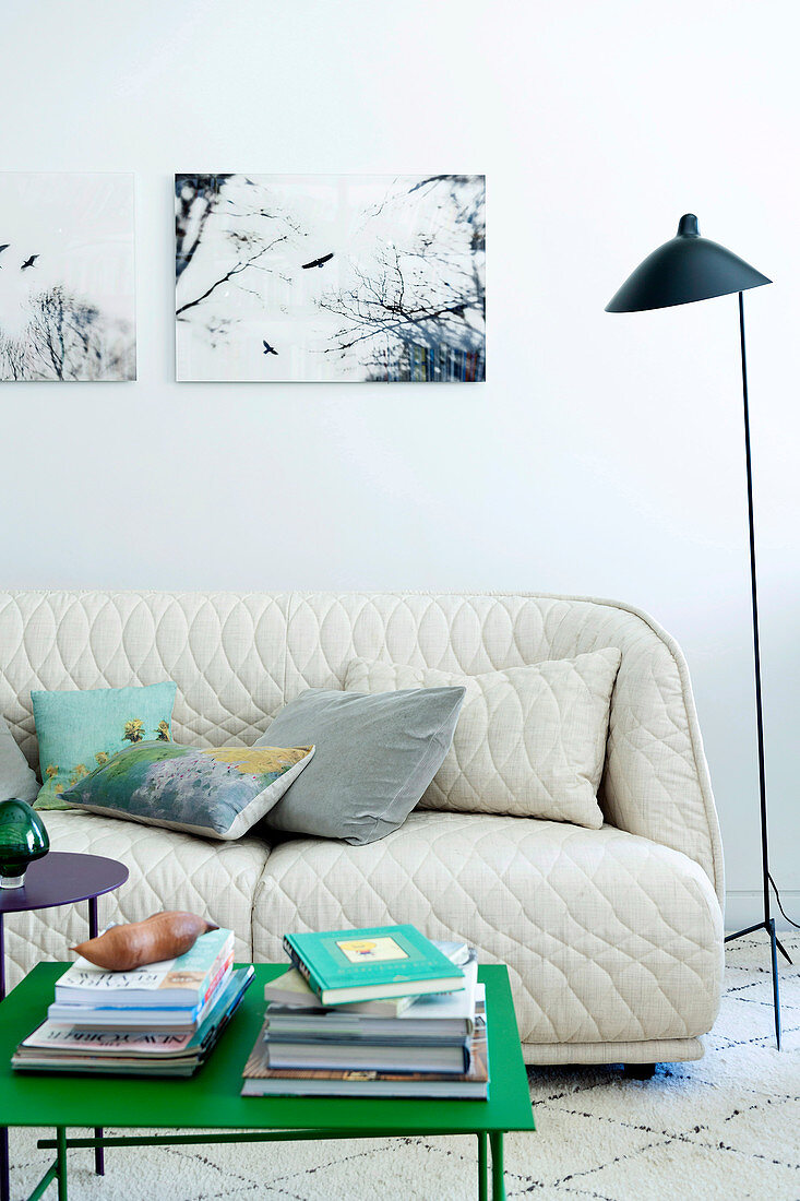 Weißes gestepptes Sofa davor moderner grasgrüner Beistelltisch