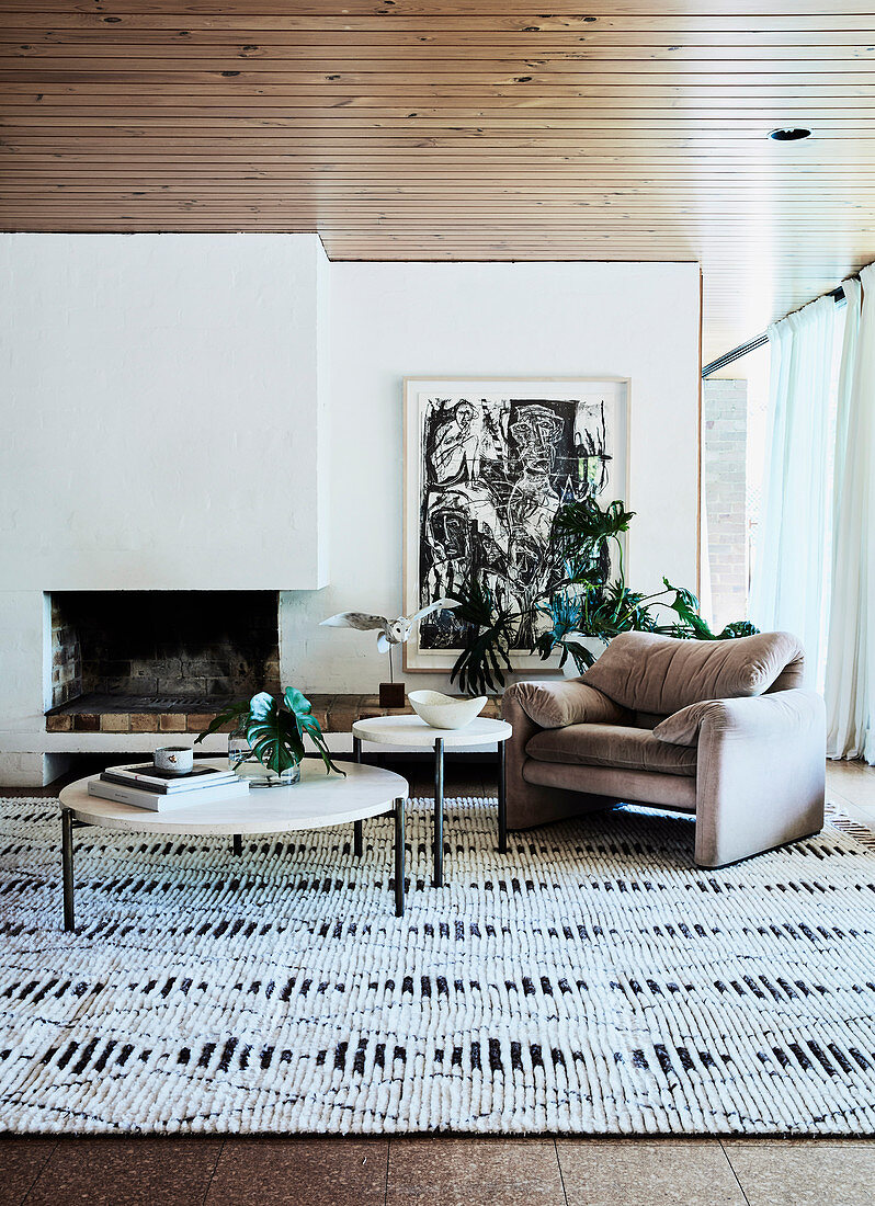 Round coffee table, armchair and graphically patterned carpet