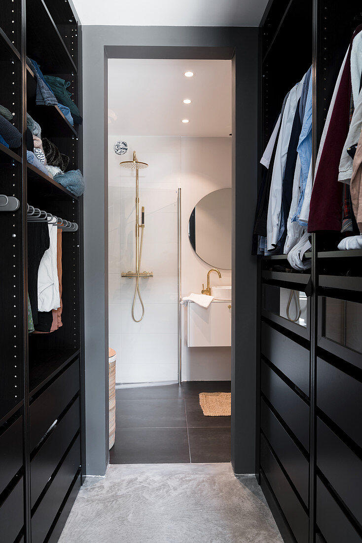 Blick vom begehbaren Kleiderschrank in modernes Bad mit Dusche und Waschtisch