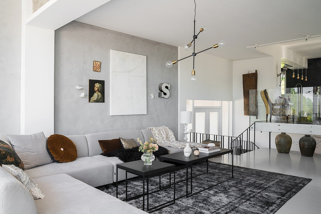 Designer-Wohnzimmer in Hellgrau mit Überecksofa, im Hintergrund Essbereich auf Split Level