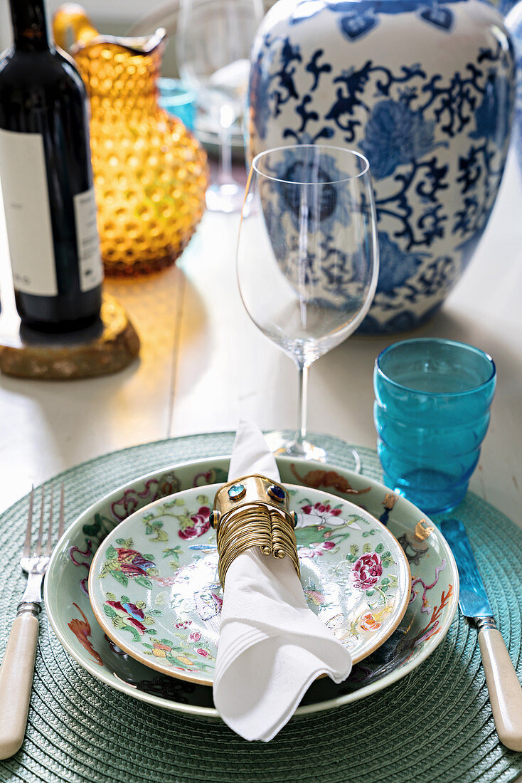 Place setting with pretty floral crockery, linen napkin and metal napkin ring