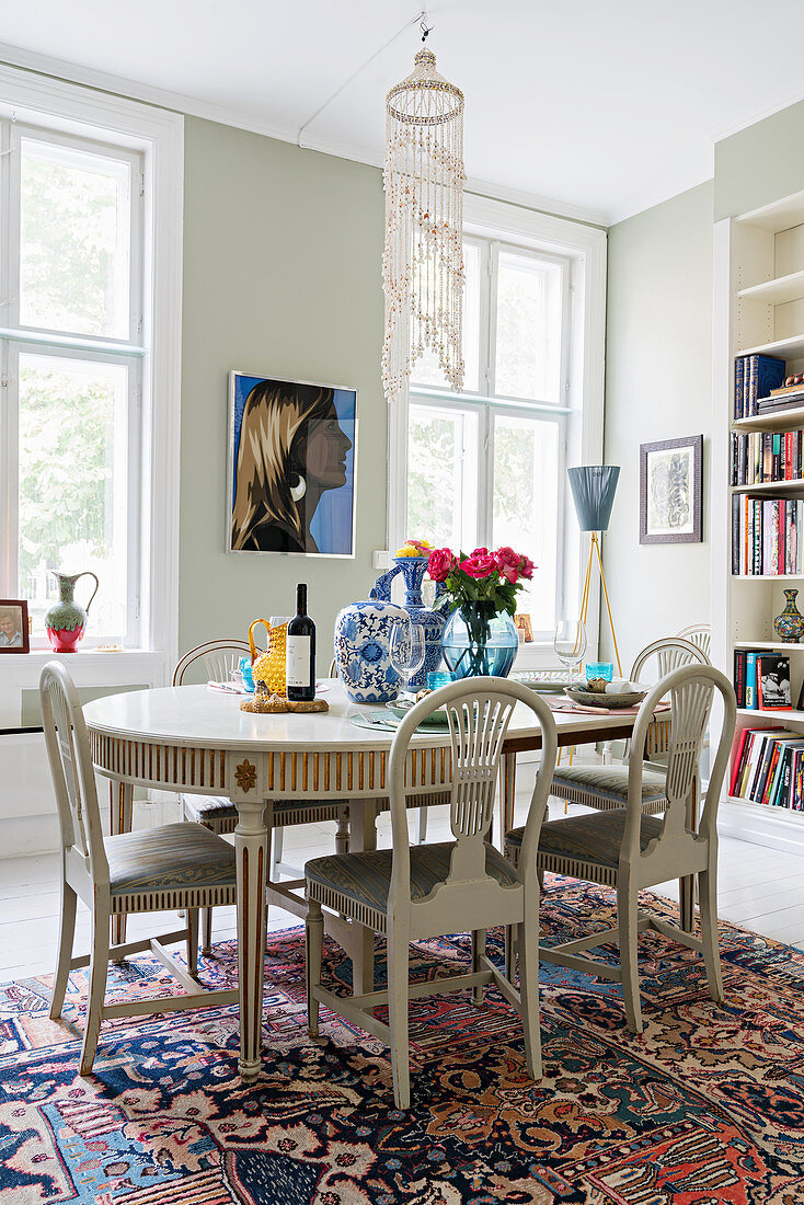 Stilvoller ovaler weißer Esstisch mit Polsterstühlen in Altbauwohnung