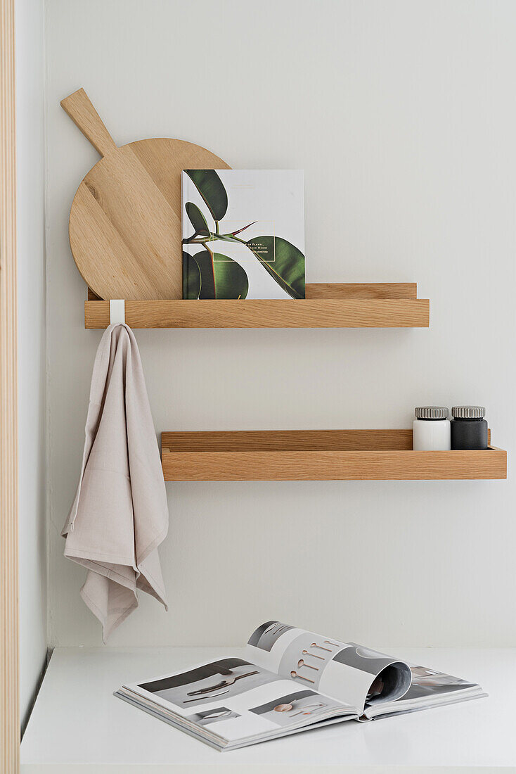 Simple wooden shelves on white kitchen wall