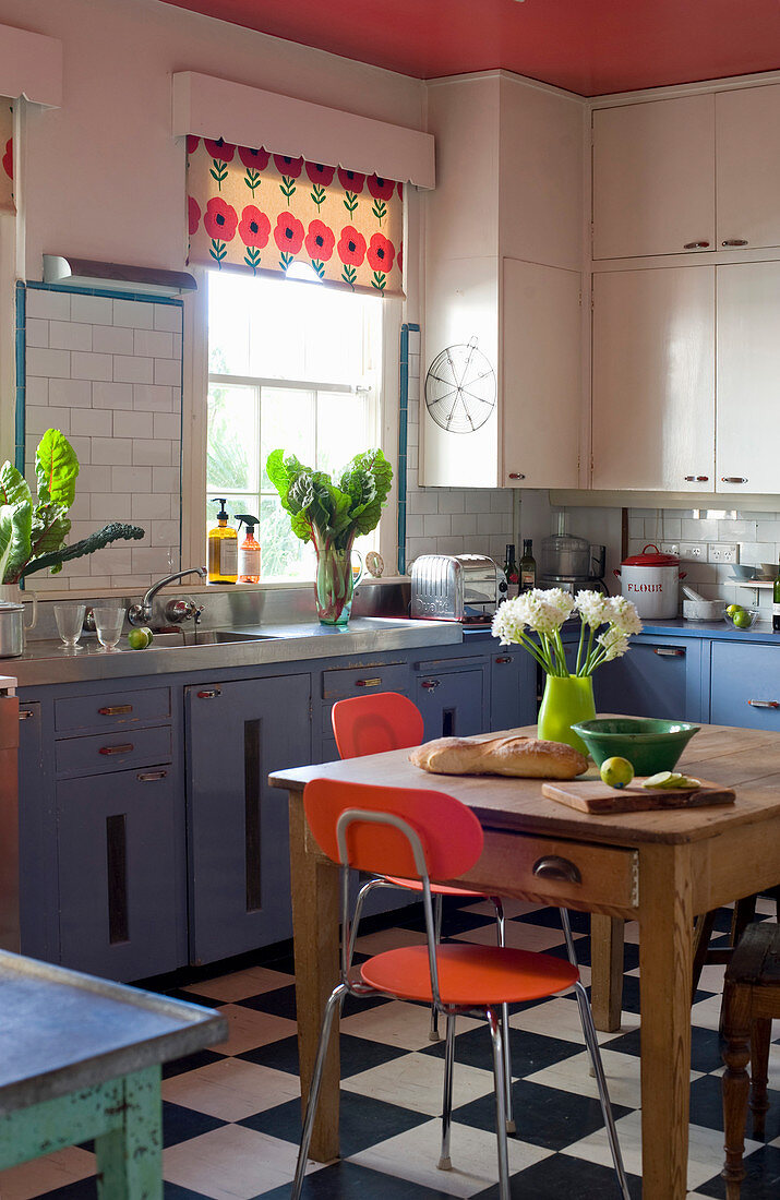 Esstisch in der Küche mit blauen Fronten und Schachbrettboden