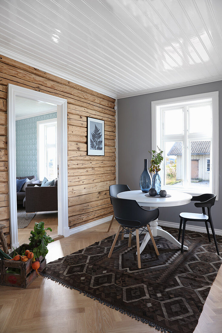 Wooden wall in dining room with open doorway leading into living room