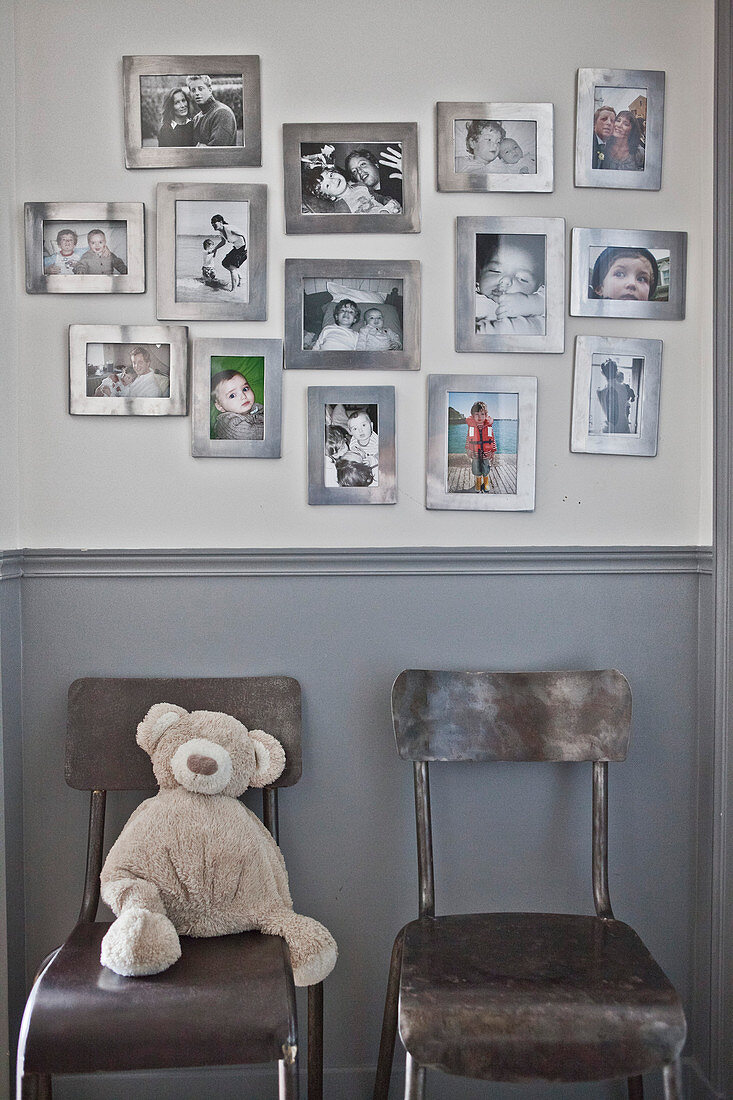 Familienbilder mit silbernen Rahmen an der Wand über zwei Stühlen