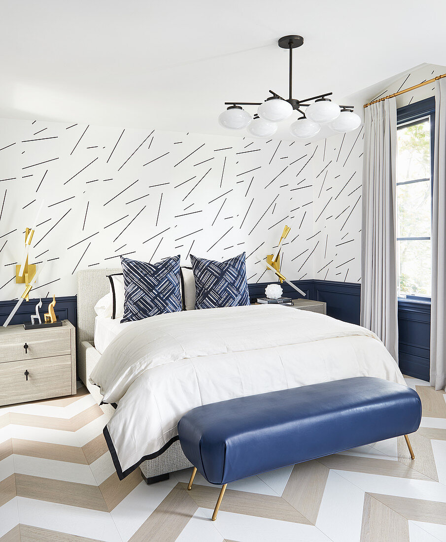 Doppelbett und blaue Leder-Kleiderbank im Schlafzimmer mit Strichmuster-Tapete, Holzboden mit Zickzack-Muster