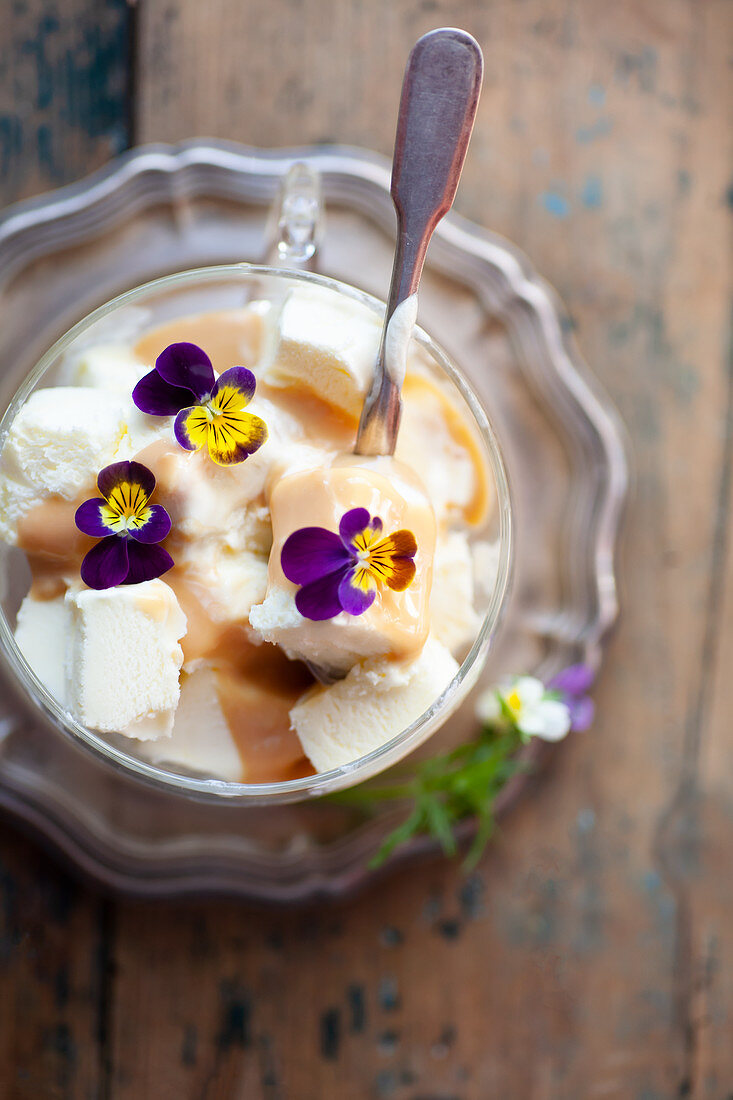Vanilleeis mit Karamellsauce und Veilchenblüten