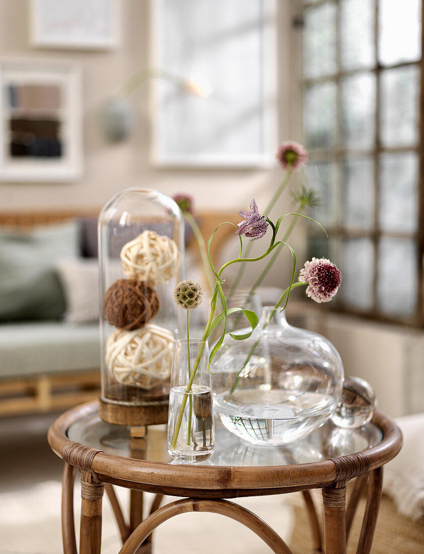 Unusual flowers in glass vases on rattan table