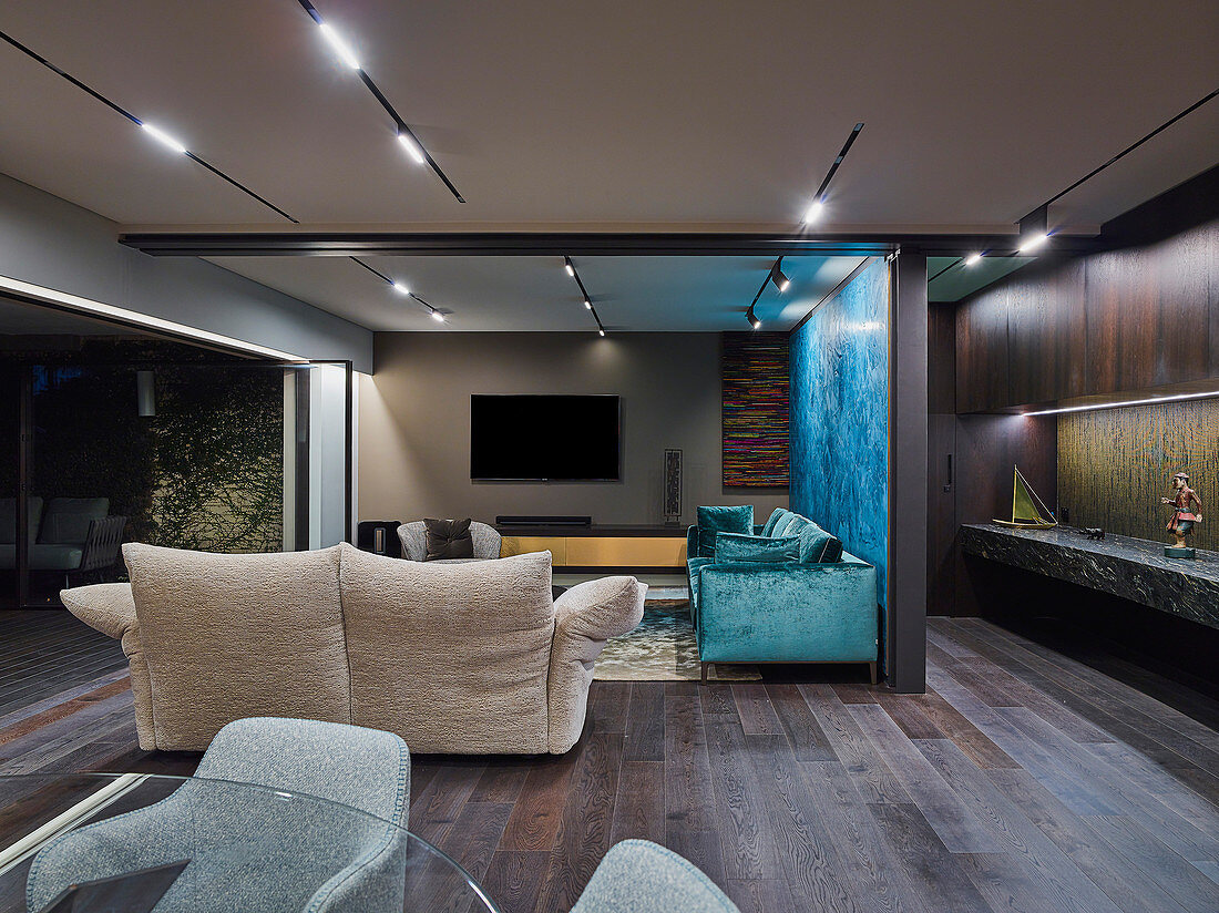 Eleganter Fernsehbereich mit Designer-Sofas in offenem Wohnraum