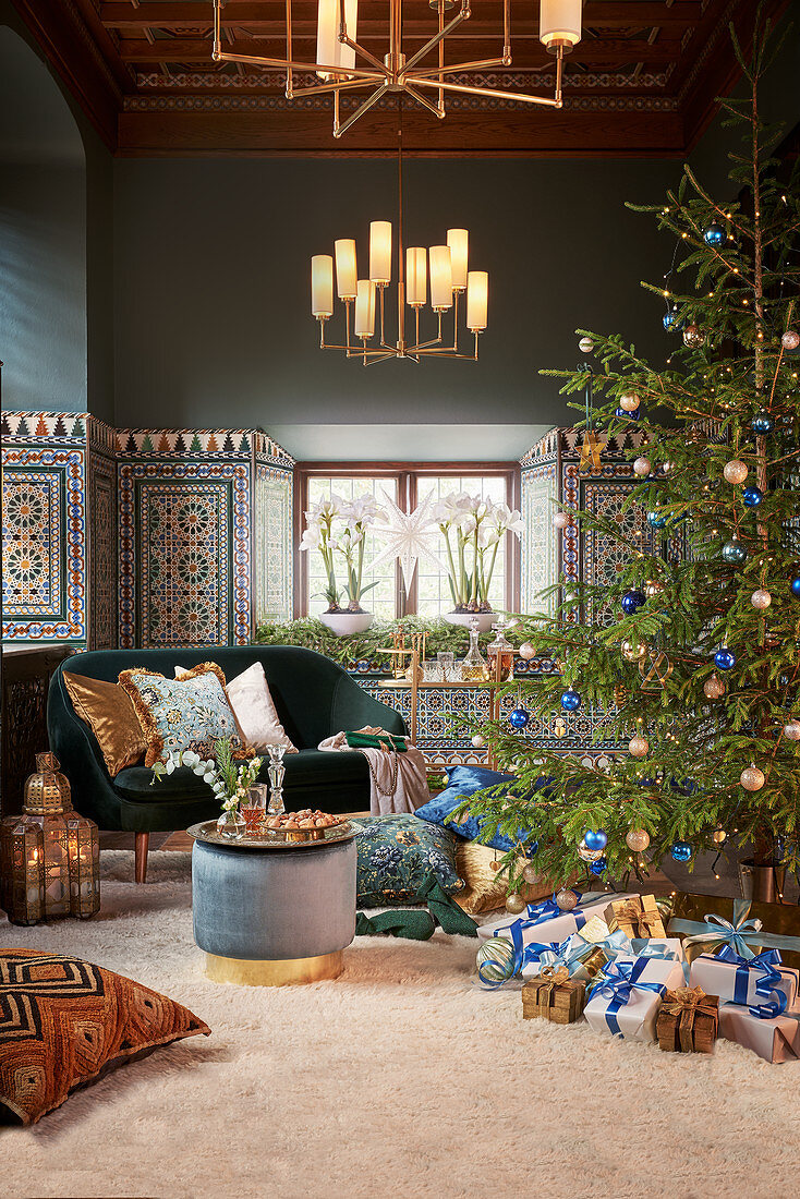 Weihnachtsbaum mit Geschenken, Beistelltisch und Sofa im Wohnzimmer mit bunten Wandfliesen
