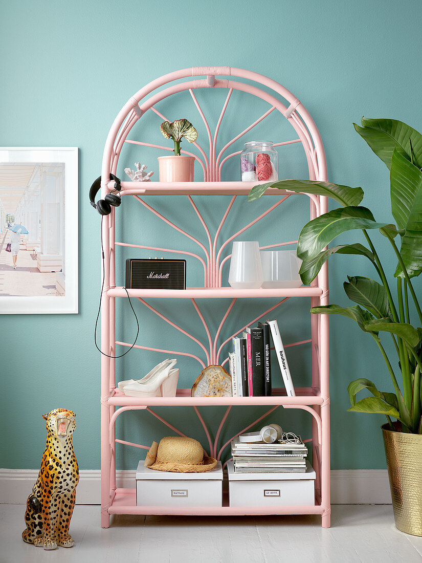 Pink rattan shelves against turquoise wall