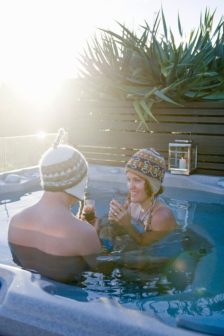 Mann und Frau mit Mützen im Pool bei Sonnenschein
