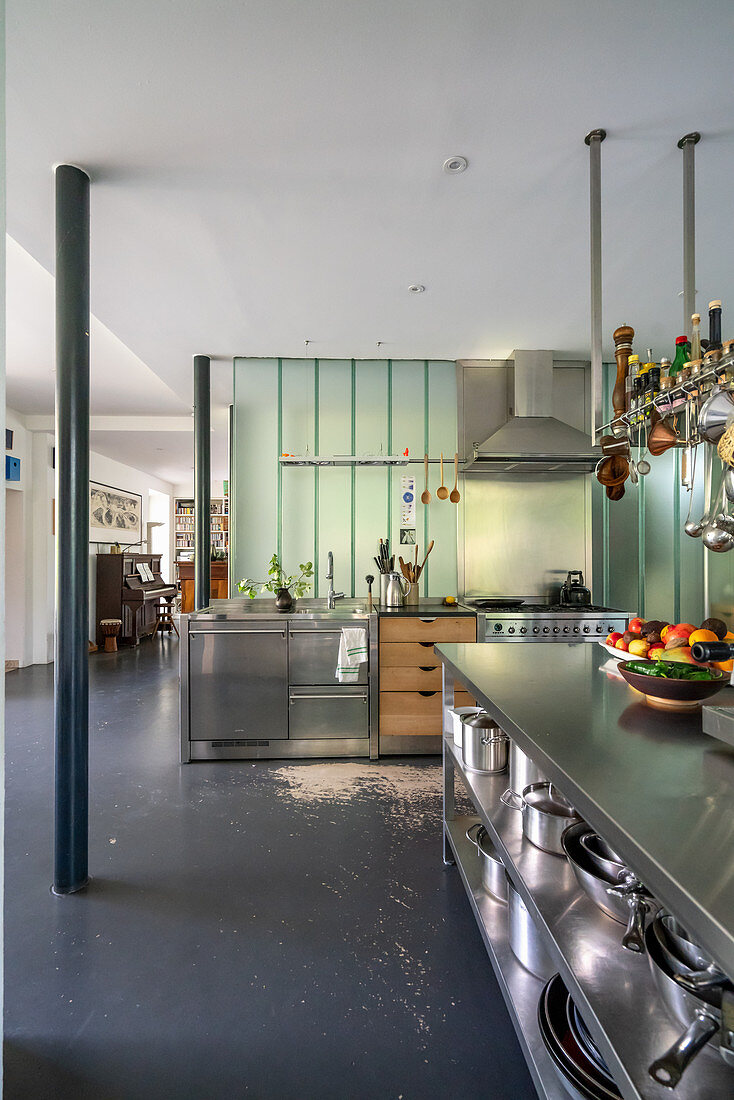 Island counter with stainless steel shelves below in open-plan interior
