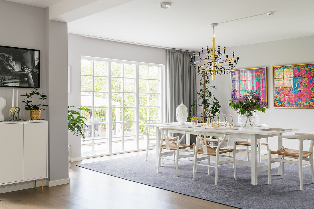 Designer chairs around white table in elegant dining room