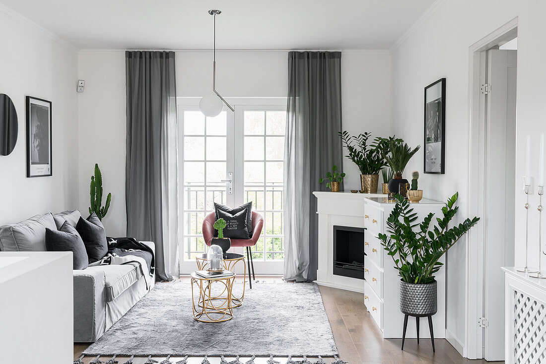 Klassisches Wohnzimmer in Grau und Weiß mit Eckkamin und Pflanzen