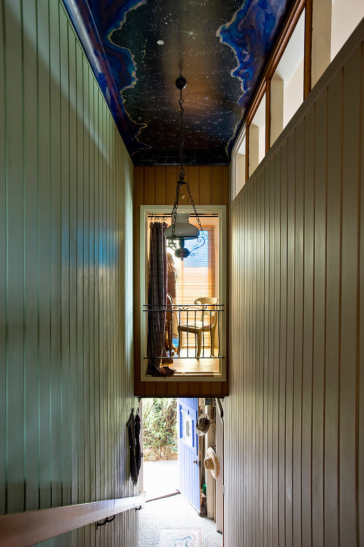 View into illuminated mezzanine in narrow hallway