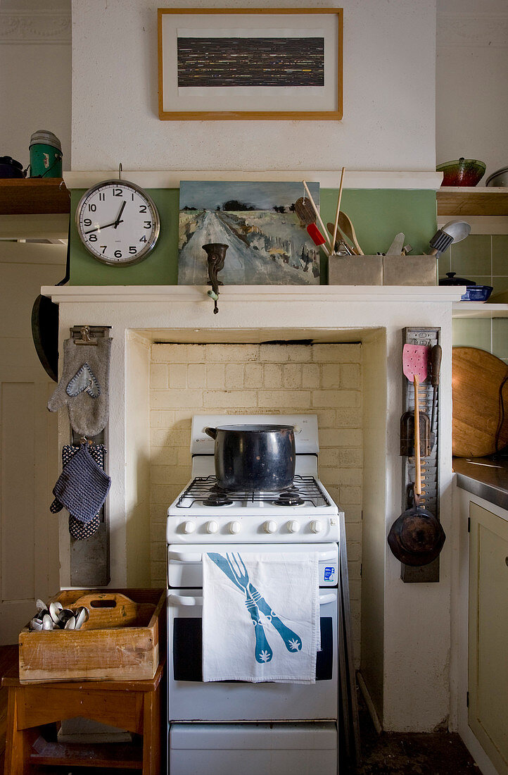 Clock above gas cooker in disused fireplace