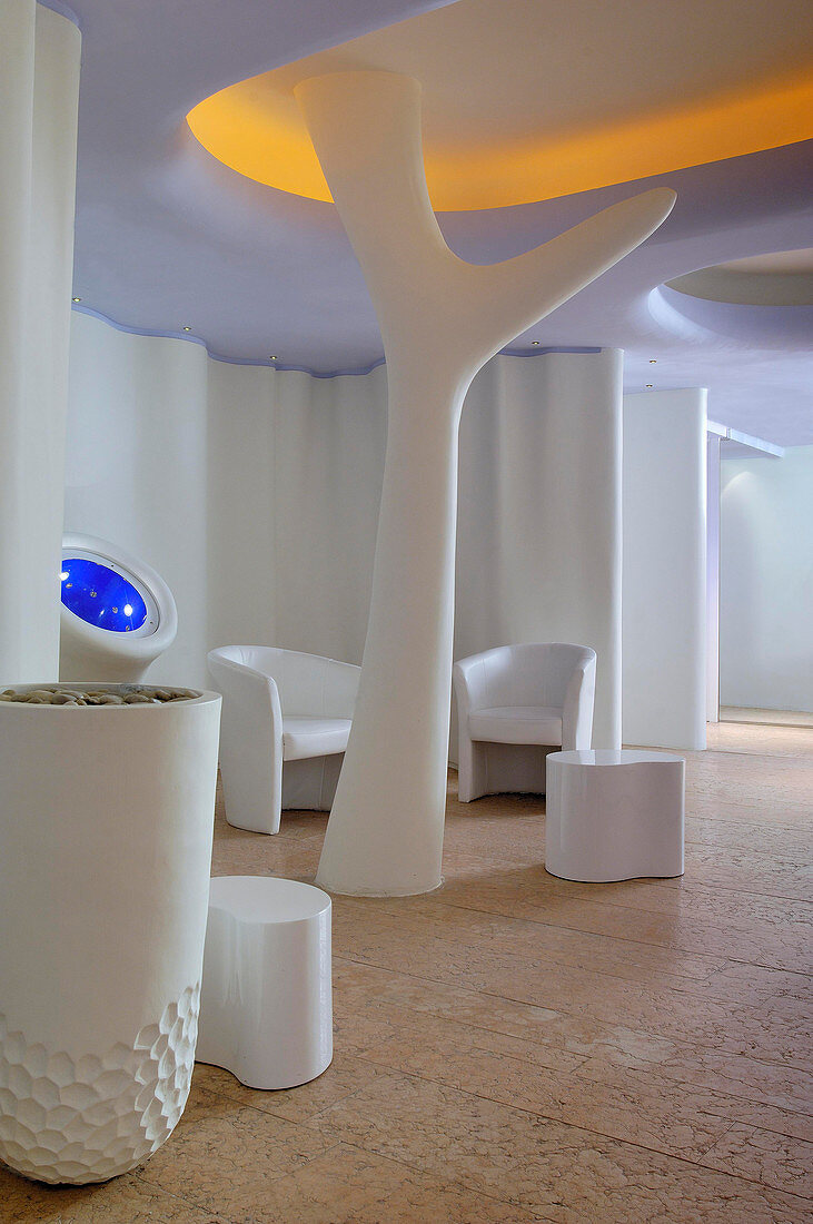 Spa-Bereich mit weißen Sitzmöbeln und baumartiger Skulptur