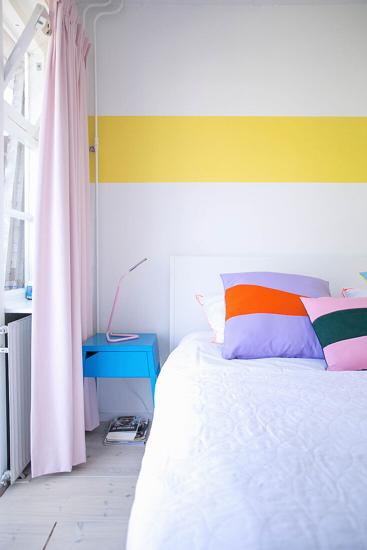 White bedroom wall with accent provided by horizontal yellow stripe