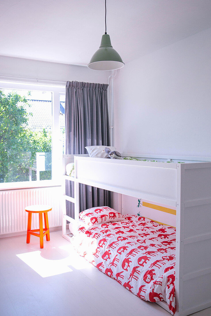 White bunk beds in light-flooded children's bedroom