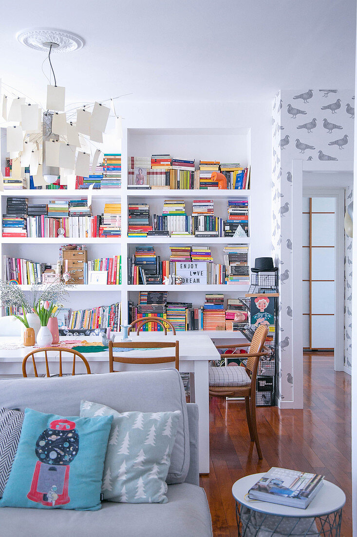 Blick über Sofa und Esstisch auf Bücherregal