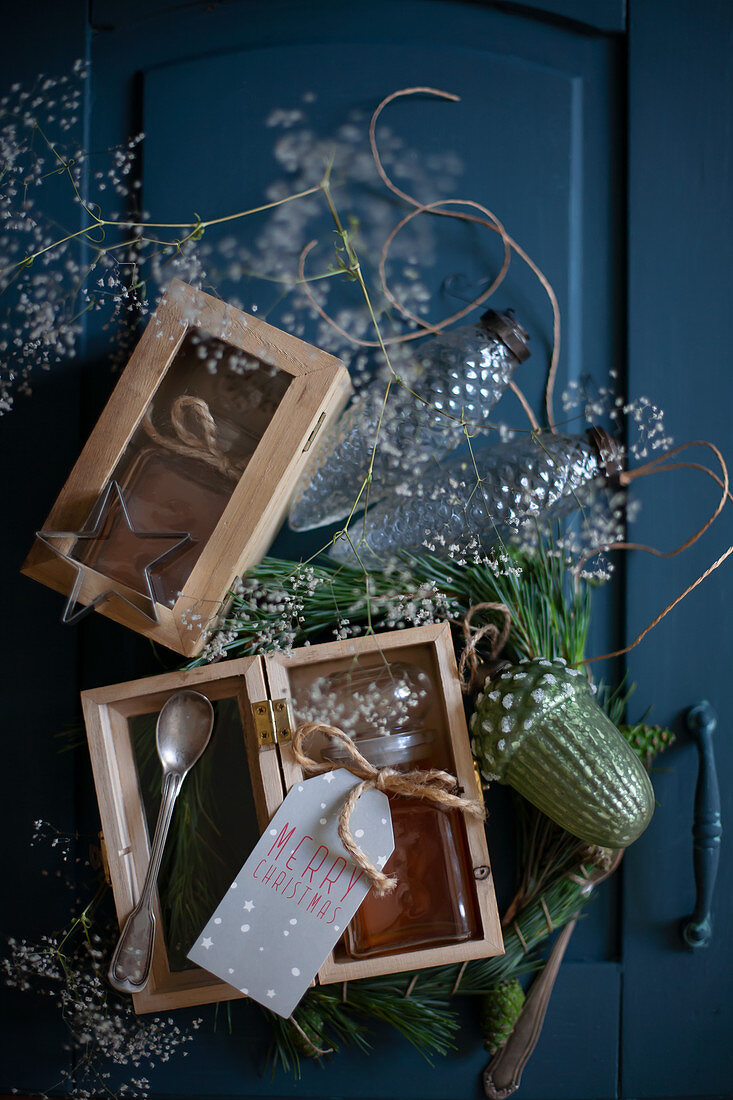 Honigglas mit Anhänger in einer Holzkiste als Weihnachtsgeschenk