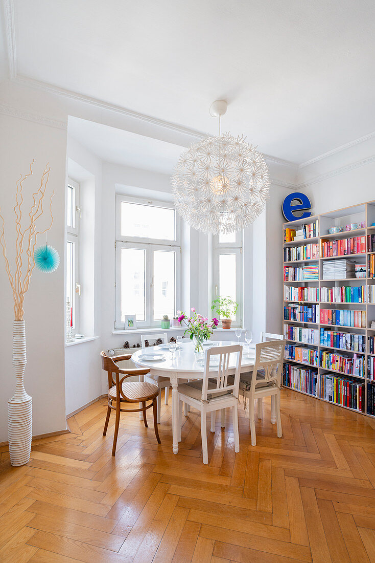Oval table and chairs in front of bookshelves