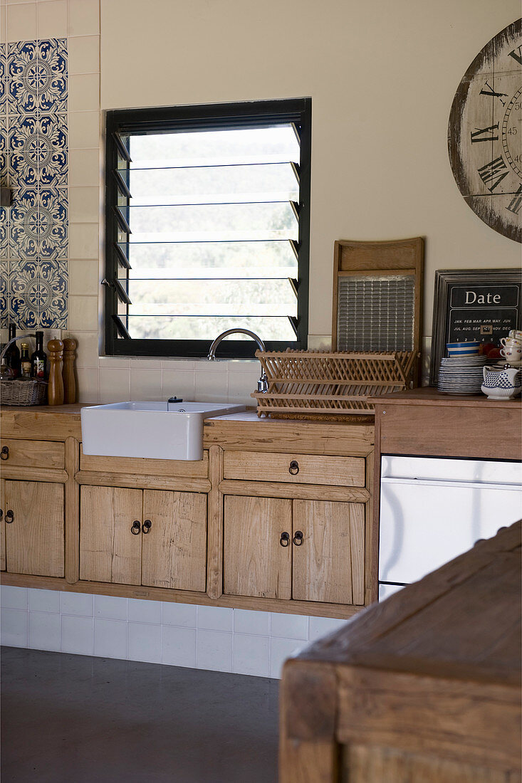 Küchenzeile mit Holzfronten und Spülbecken unter dem Fenster