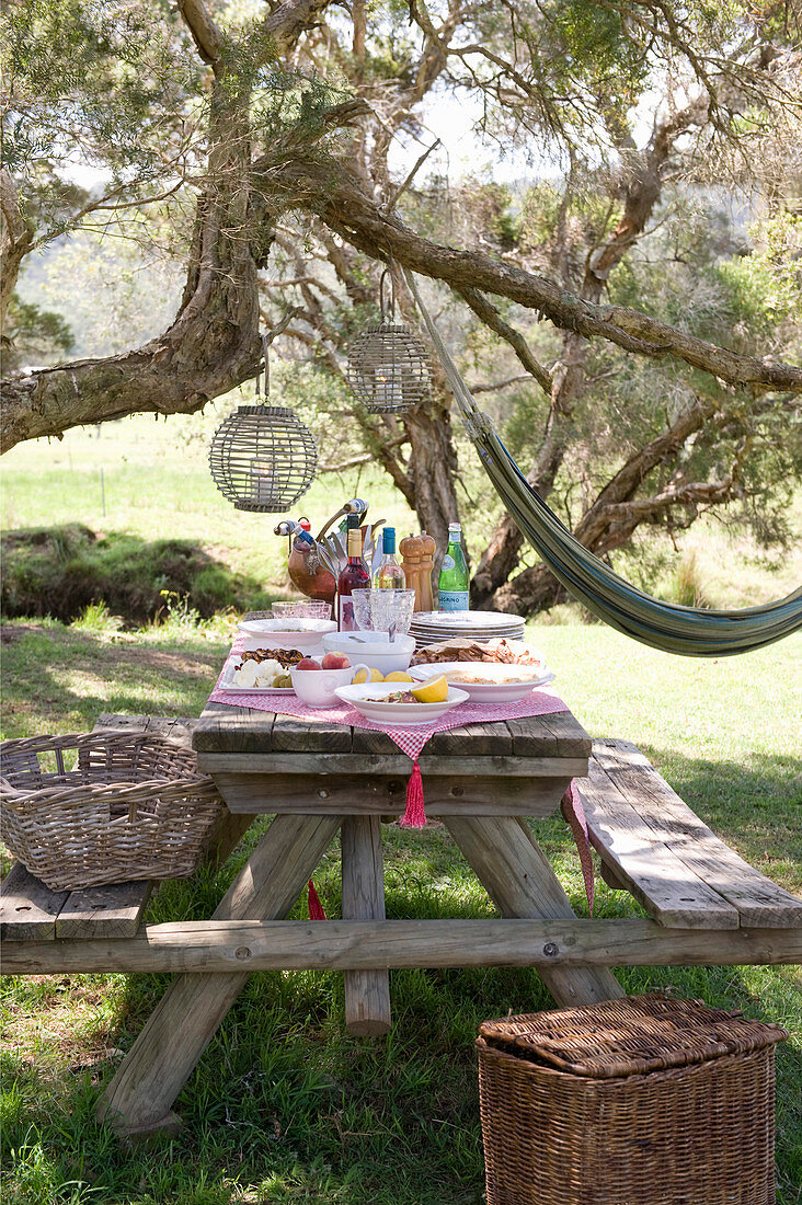 Rustic wooden picnic table set for meal in garden