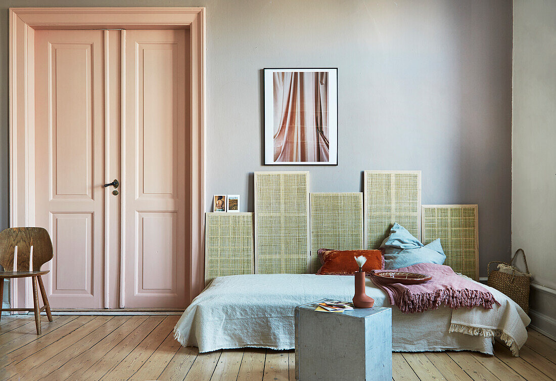 Couch against woven wall panels next to panelled door