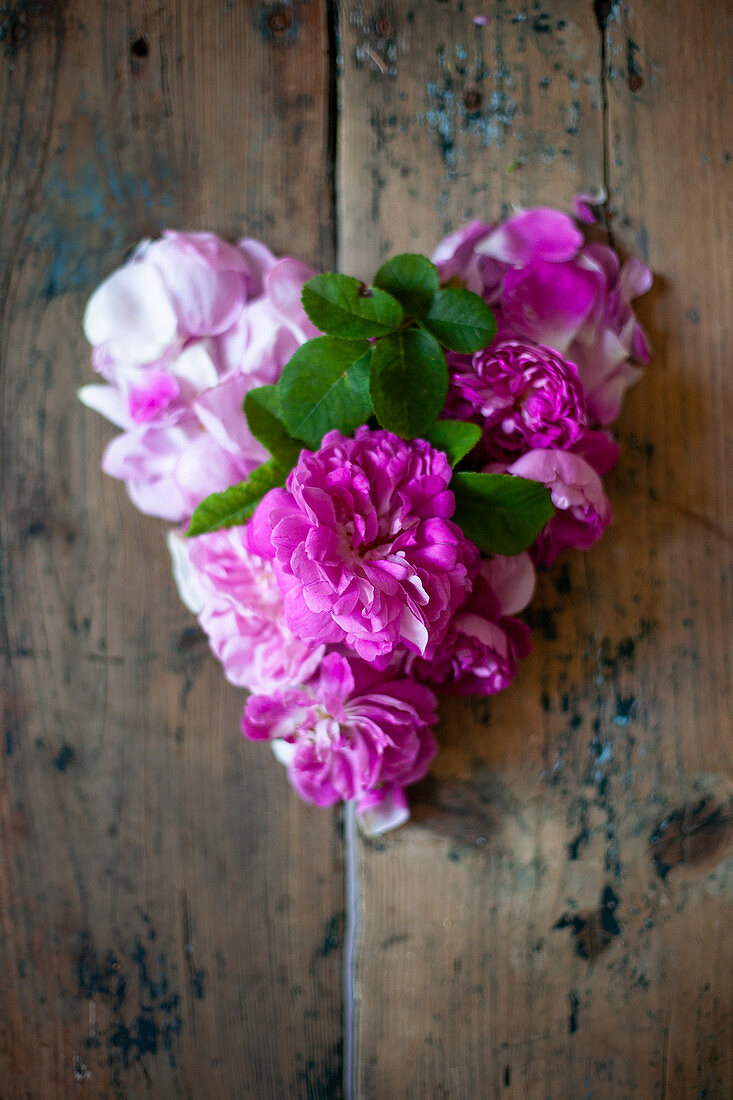 Pinkfarbene Rosen auf Holztisch
