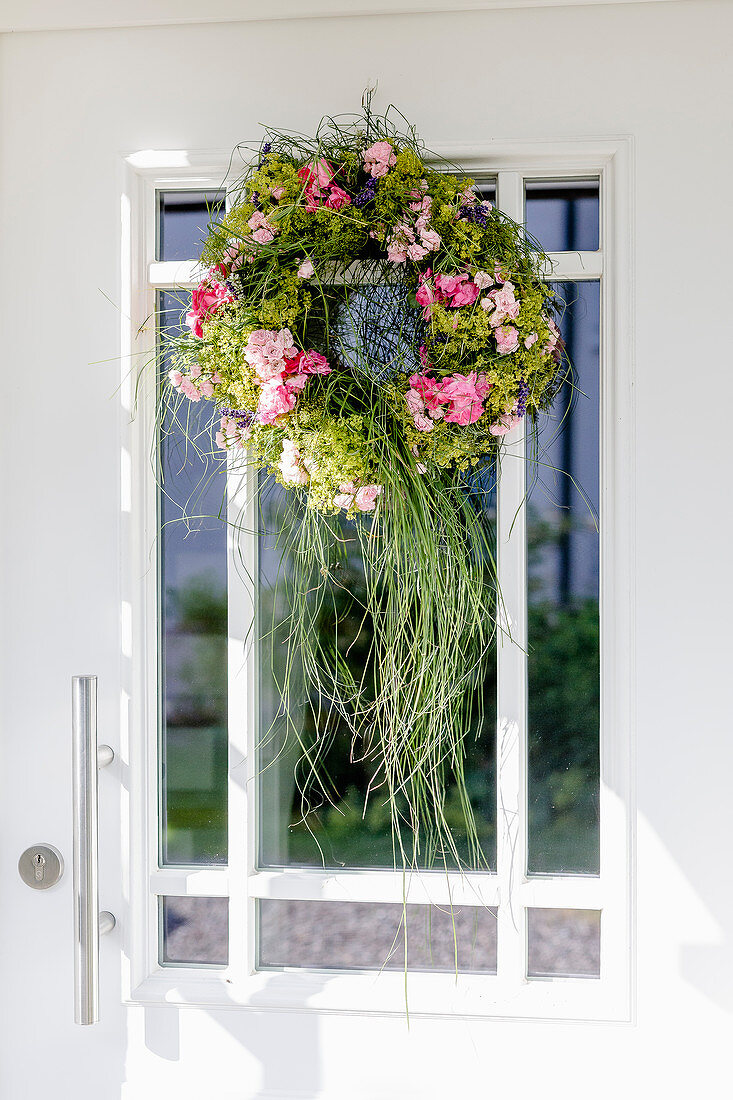 Door wreath with roses and grass on the front door