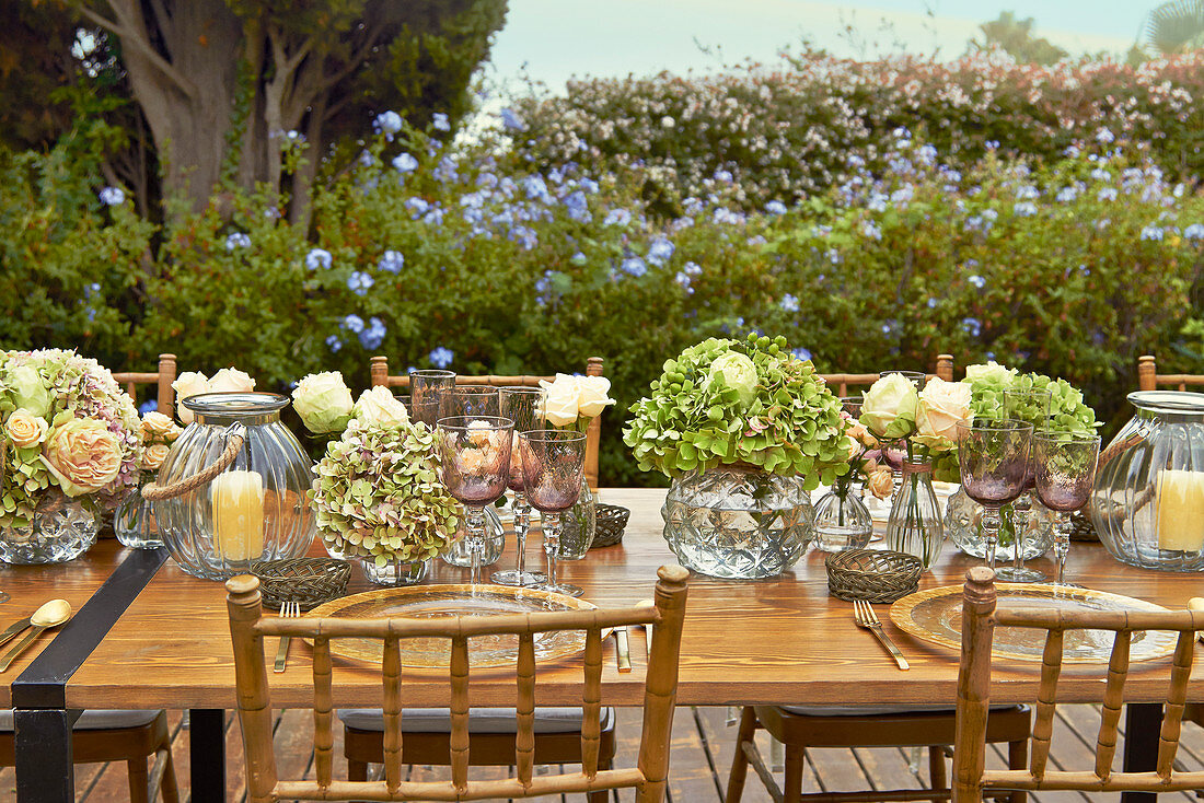Festlich gedeckter Tisch mit Hortensien, Rosen und Windlichtern