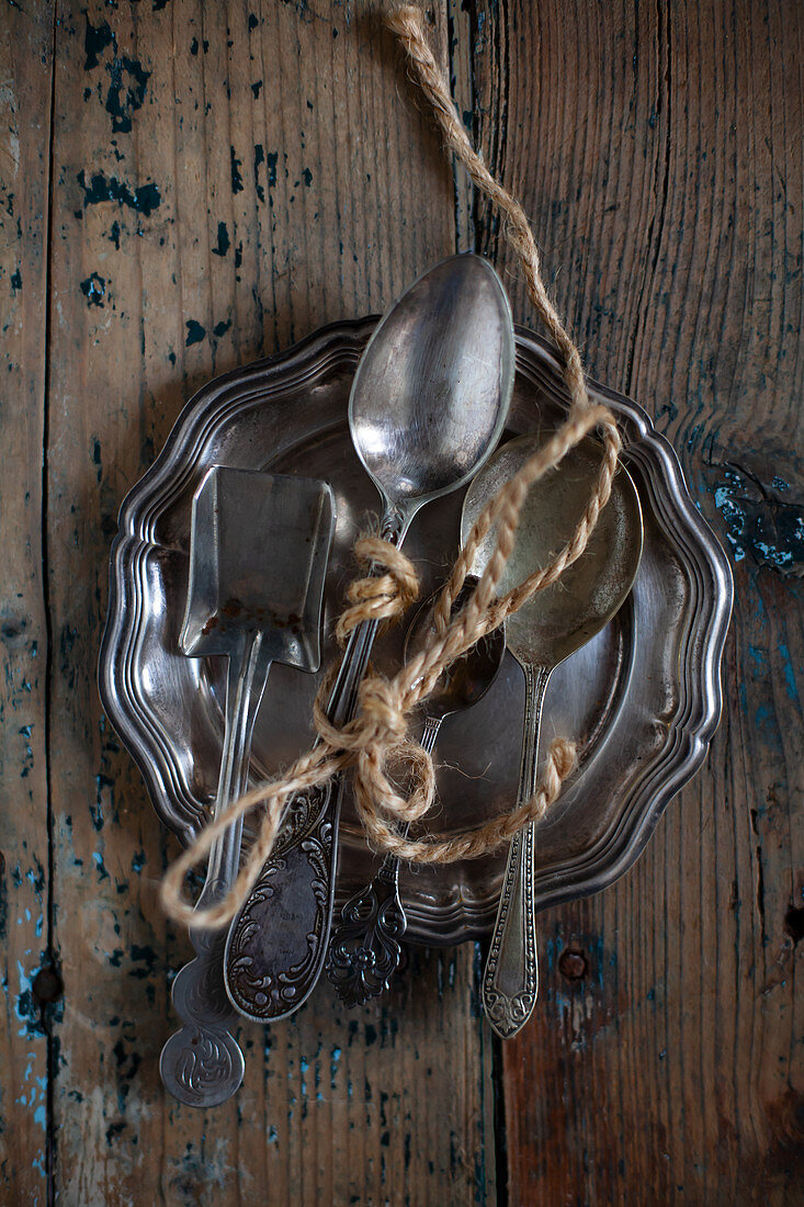Silver spoons tied with yarn on tray
