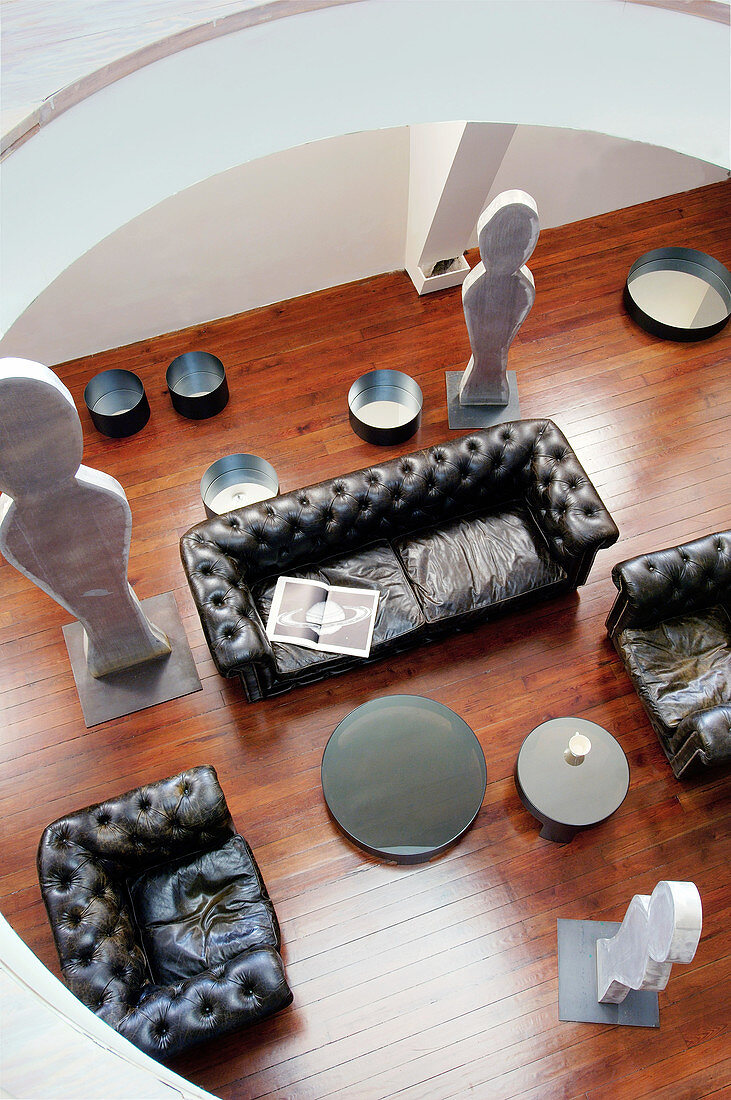 View down onto leather sofa set and sculptures in loft apartment