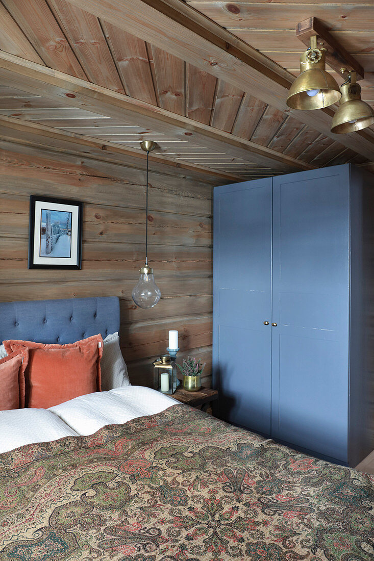 Blauer Kleiderschrank im rustikalen Schlafzimmer im Blockhaus