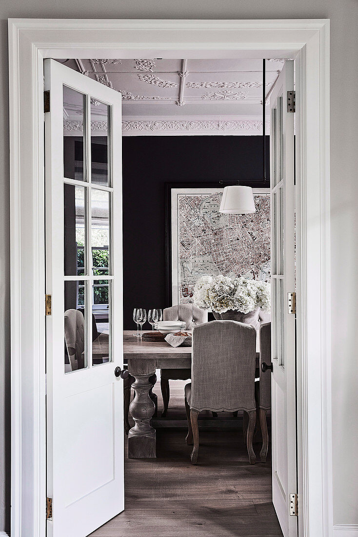 View through open double doors into the elegant dining room in grey tones